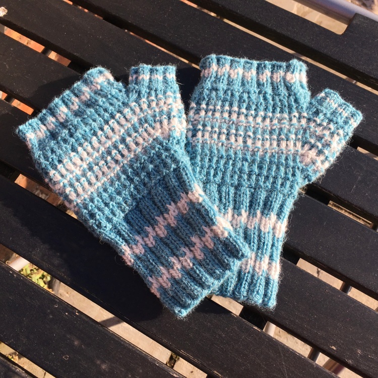 A picture of Nubble Slip Stitch Mitts on a slatted table.